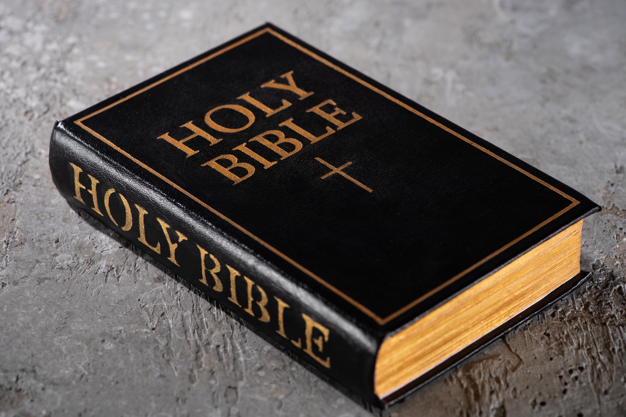 holy bible on grey textured surface J. U. Passion - Realtor, Writer, Preacher, Teacher