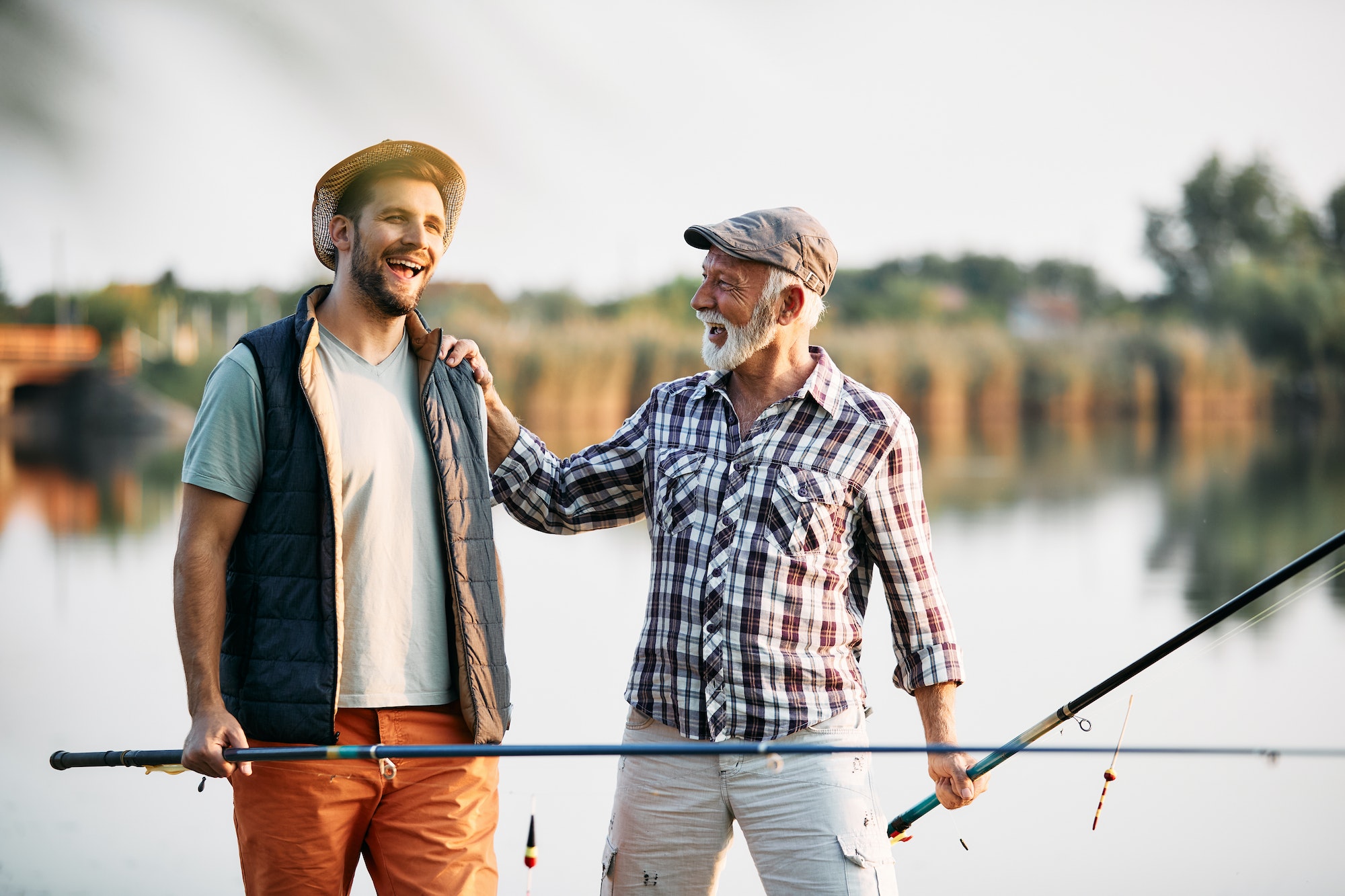 Cheerful father and son having fun during their fishing day in nature.